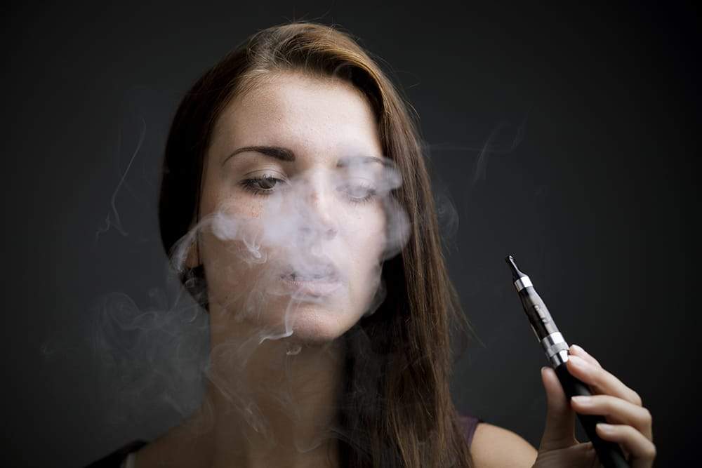 vap1_3af8a9b7-8d0b-4d46-aa30-97d09d4c2ca4 women vaping an ecig, what are the risks?